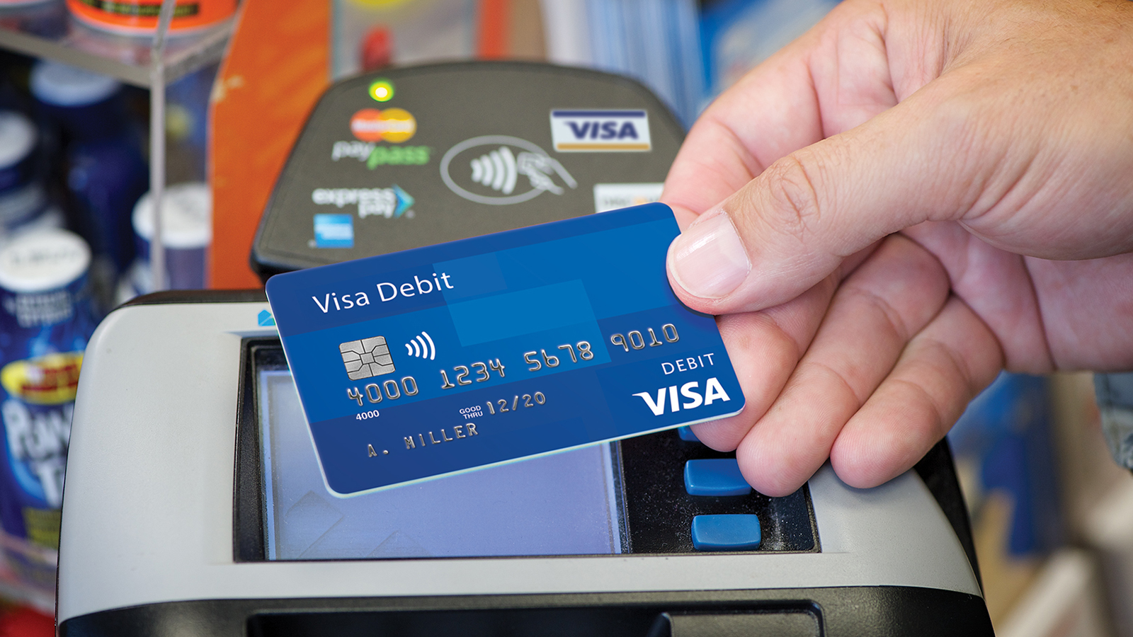 cashier-paywave-1600x900 Presenting a contactless Visa debit card at checkout.
