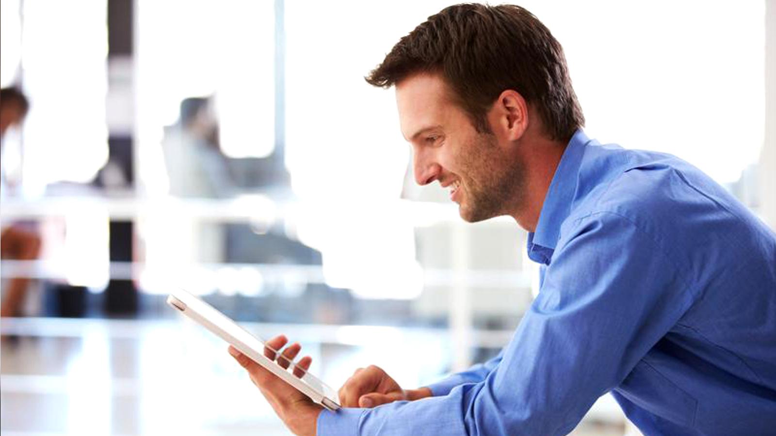 man-tablet-1600x900 Man smiling at a tablet.