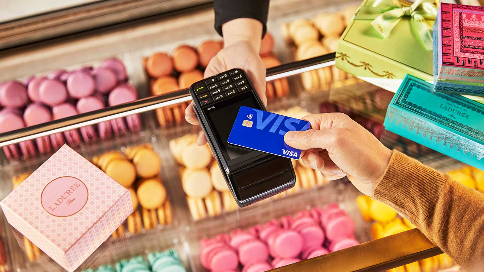 An individual using a Visa contactless card to buy cookies.