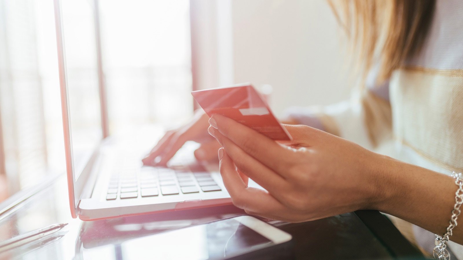 Woman with card and laptop.