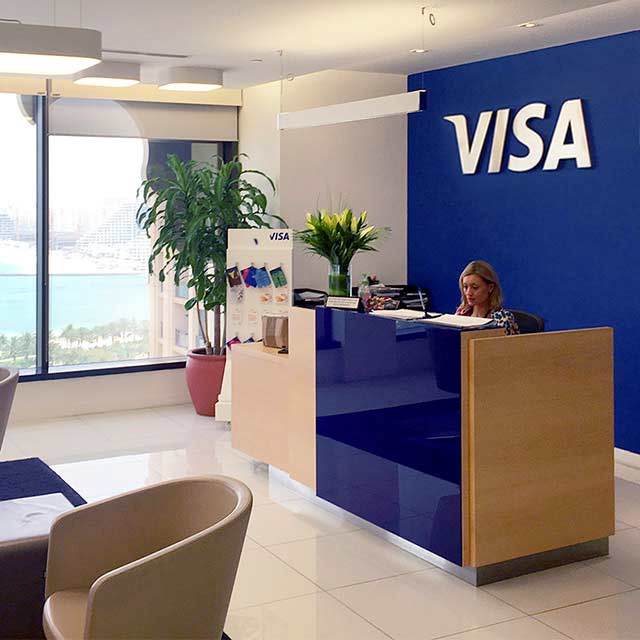 The reception area of the Dubai Innovation Center, which includes a Visa logo on the wall.