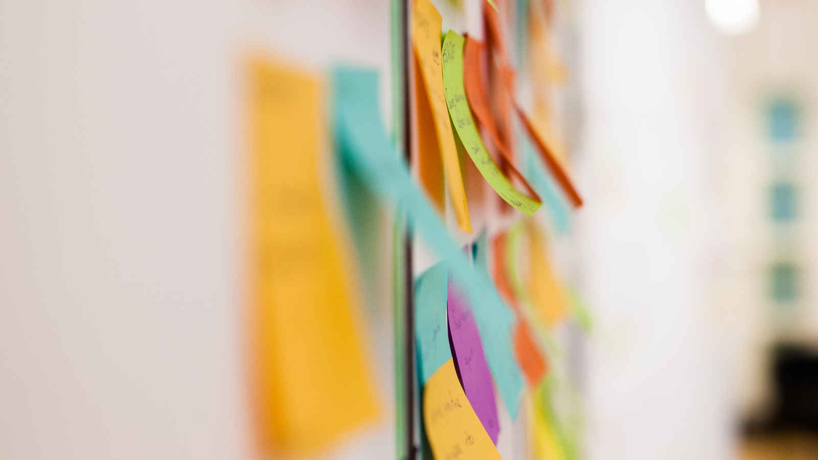 Close up of green and orange post-it notes.