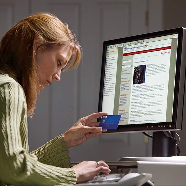 A woman sitting at her computer, utilizing secure payment options to ensure the safety and security of her online transactions. 