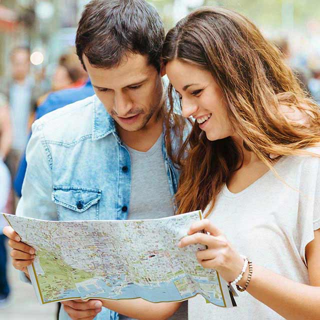 Couple looking at a map for directions in a busy street