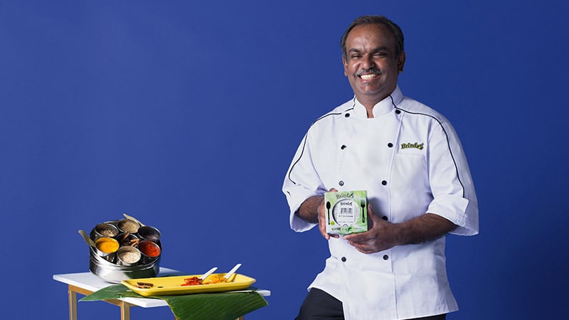 A professional chef presents a tray of food, promoting the importance of supporting local businesses. 