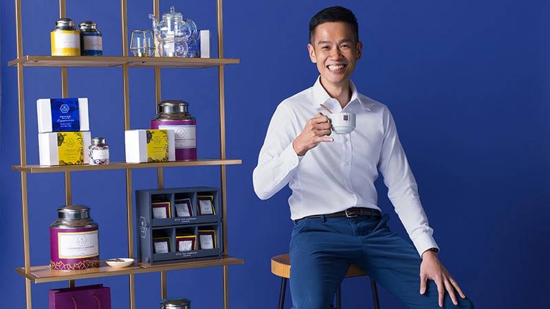 A man sitting on a chair and enjoying a cup of tea, promoting shopping with a small business. 