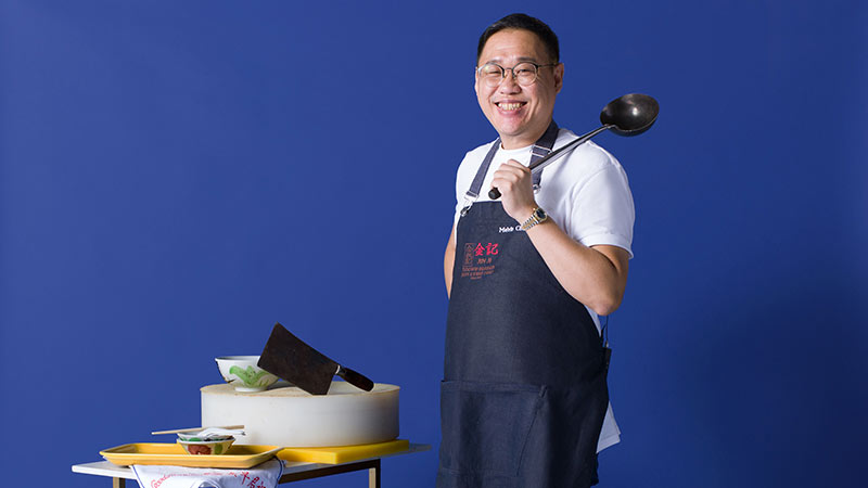 A man standing in front of a table with food, promoting support for local businesses.